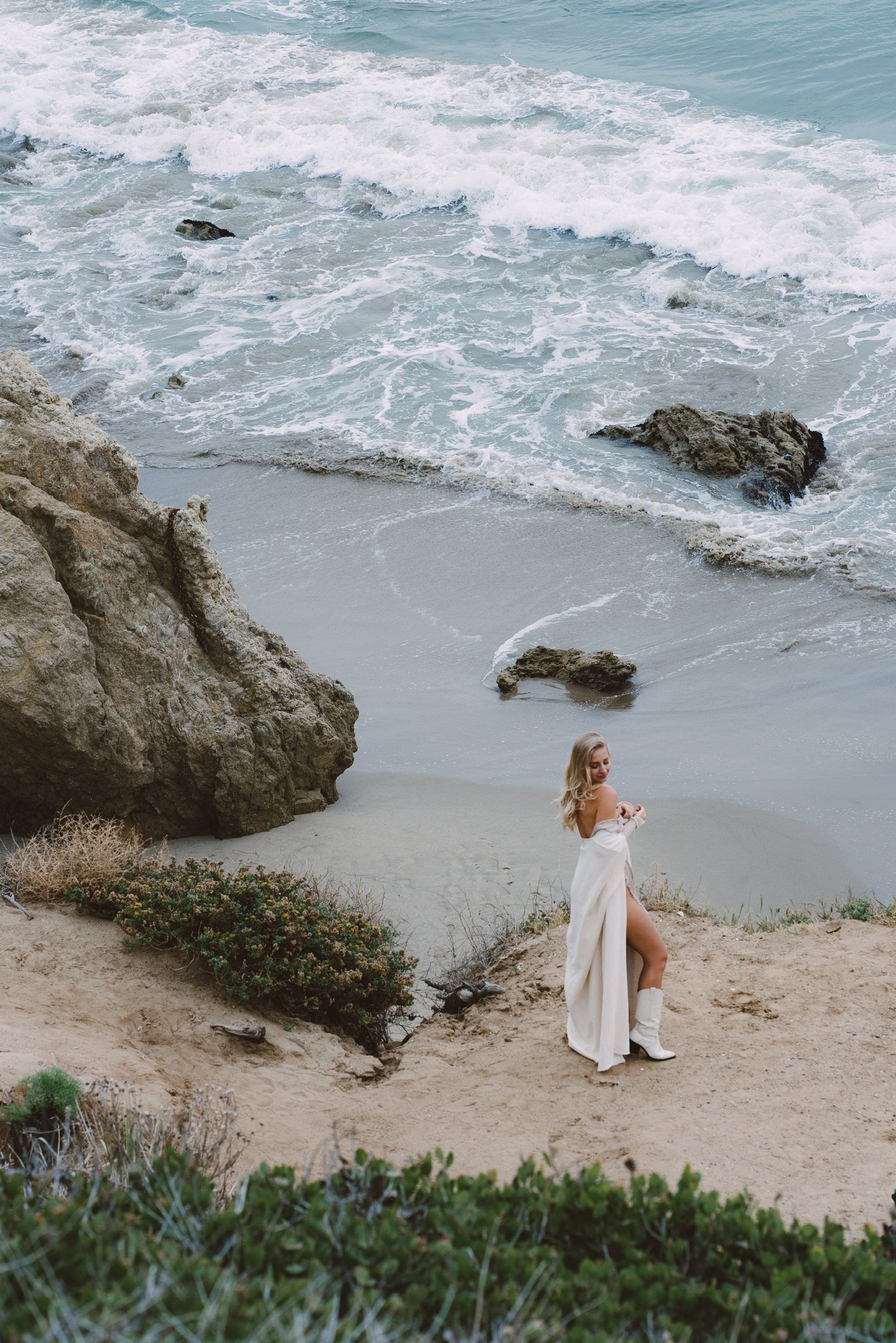 Model wearing ASHIK polka cape on the shore